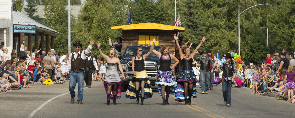 A parade float in the Golden Days Parade surrounded by joyful spectators and parade walkers.