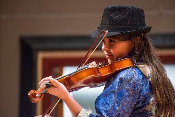 a young Alaska native woman playing a violin
