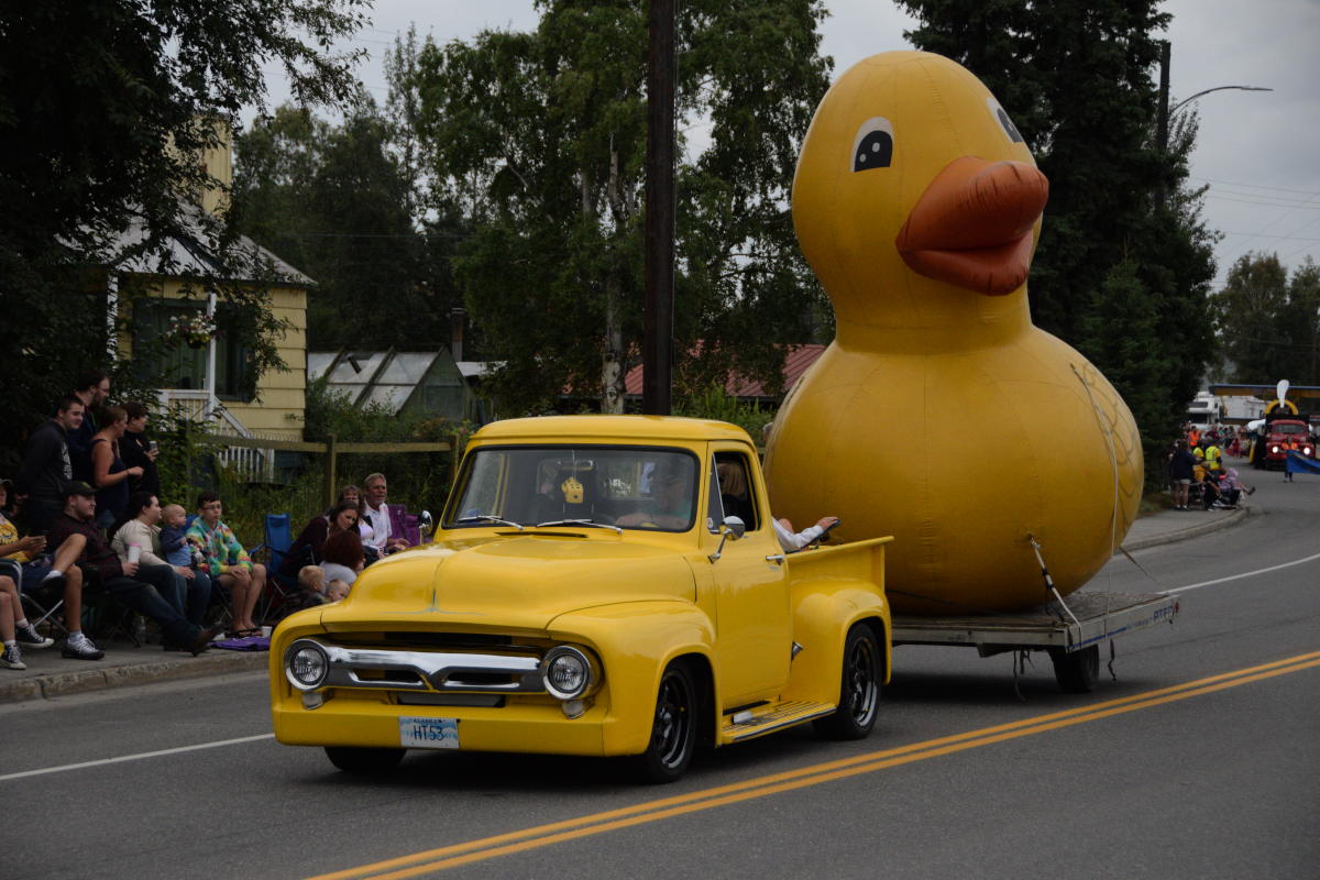 An antique truck pulling a giant inflatable yellow duck in the Golden Days parade.