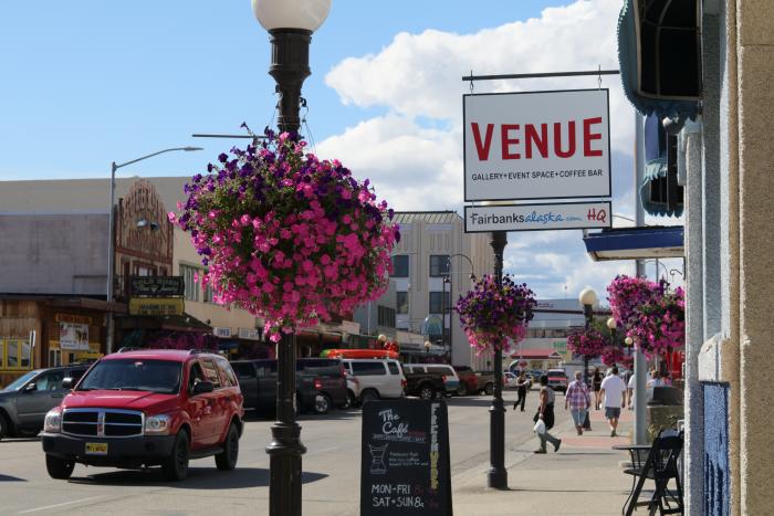 street scene in summer with hanging flower baskets along byway