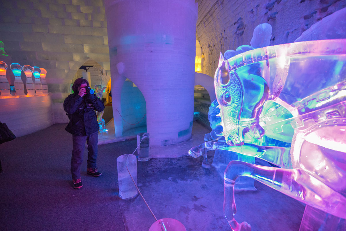 Someone taking a picture of a colorful ice sculpture