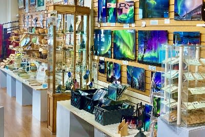 An art gallery wall with photographs and jewelry 