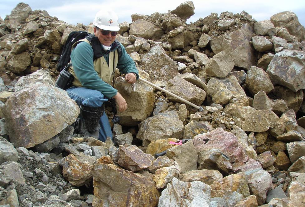 Person sitting on large pile of rocks
