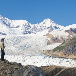 Two people standing in front of glacier and Mr. Blackburn at Wrangell Mountains